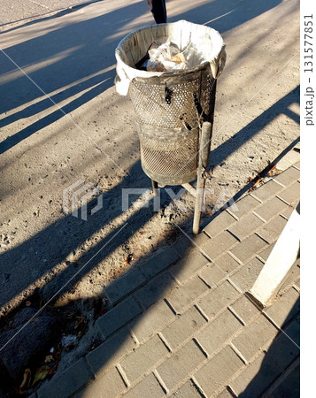 Trash Can on the Street Surrounded by Shadows Reflecting Early Morning Light Trash Can on the Street Surrounded by Shadows Reflecting Early Morning Light 131577851