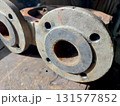 Cast Iron Industrial Pump Housing Flanges Displayed on a Wooden Workbench in a Workshop Setting 131577852