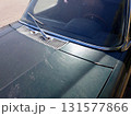 Old Dark Green Car Parked in a Quiet Area on a Sunny Day Capturing Nostalgia and Vintage Charm 131577866