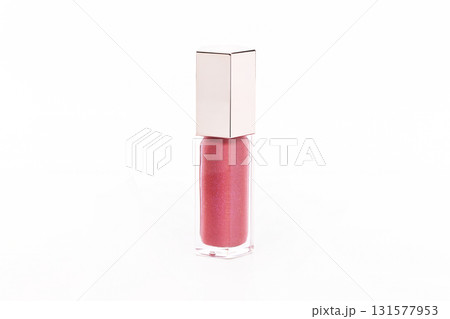 A small bottle of pink lip gloss sits on a white background A small bottle of pink lip gloss sits on a white background 131577953