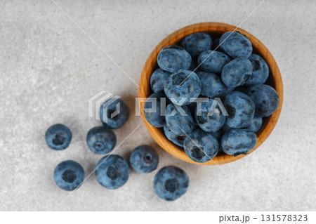 Fresh ripe blueberries in wooden bowl on light gray stone background closeup macro healthy food 131578323