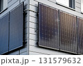 Modern Building Exterior With Solar Panels Mounted On Grey Siding Wall: Sustainable Energy Technology, Clean Power Source, Photovoltaic Cells, Environmental Friendly Design Under Natural Daylight 131579632