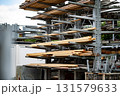 Industrial Storage Racks Holding Various Sizes Of Wooden Planks Outdoors In Construction Yard Under Overcast Sky 131579633