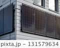Modern Building Exterior With Solar Panels Mounted On Grey Siding Wall: Sustainable Energy Technology, Clean Power Source, Photovoltaic Cells, Environmental Friendly Design Under Natural Daylight 131579634
