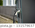 Electric Vehicle Charging Station With Dual Connectors: Close-Up Of Modern EV Power Supply Cables And Sockets With Green LED Outlines On Black Panel In Urban Setting 131579637
