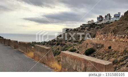 A scenic journey along a winding road offers stunning ocean views 131580105