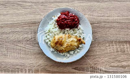 A visually appealing plate of rice, chicken a flavorful sauces 131580106
