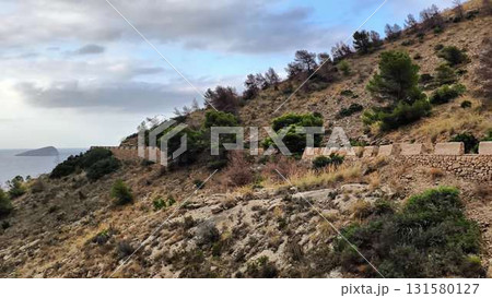 A stunning hillside landscape with a stone wall and a serene view A stunning hillside landscape with a stone wall and a serene view 131580127