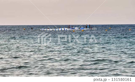 Friends gather on a raft in the ocean, enjoying laughter 131580161