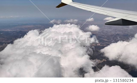 Aerial View of the Cloudy Landscape as Seen from an Airplane Window Up in the Sky Aerial View of the Cloudy Landscape as Seen from an Airplane Window Up in the Sky 131580234