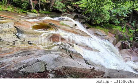 A Stunning Scenic Waterfall Cascading Gracefully Over Vibrant Colorful Rock Formation 131580268