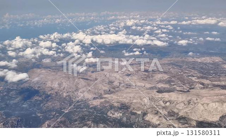 Aerial view of stunning landscapes with clouds and majestic mountains stretching for miles 131580311