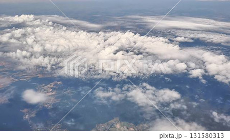 Experience the breathtaking aerial view of beautiful cloud patterns over a scenic landscape 131580313