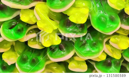 A vibrant and colorful assortment of gummy frog candies piled together in a playful way A vibrant and colorful assortment of gummy frog candies piled together in a playful way 131580389