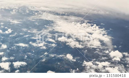Behold an Aerial View showcasing the magnificent Clouds and Earth from a soaring Airplane Behold an Aerial View showcasing the magnificent Clouds and Earth from a soaring Airplane 131580418