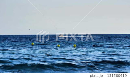 It truly is a Beautiful Day on the Ocean featuring a Speedboat alongside colorful Buoys 131580419