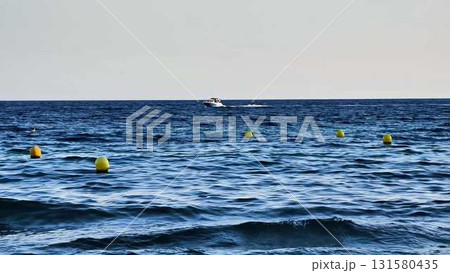 Experience a beautiful scenic ocean view featuring a boat gliding past vibrant yellow buoys Experience a beautiful scenic ocean view featuring a boat gliding past vibrant yellow buoys 131580435