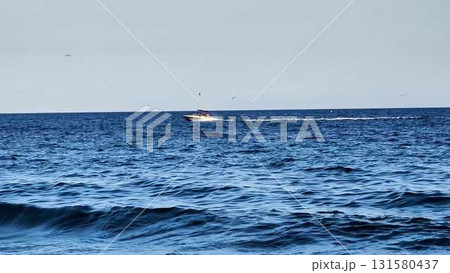 A Speeding Boat Gliding Across a Beautiful and Calm Ocean Surface on a Sunny Day A Speeding Boat Gliding Across a Beautiful and Calm Ocean Surface on a Sunny Day 131580437
