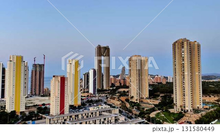 A stunning modern cityscape featuring tall highrise buildings against a clear blue sky 131580449