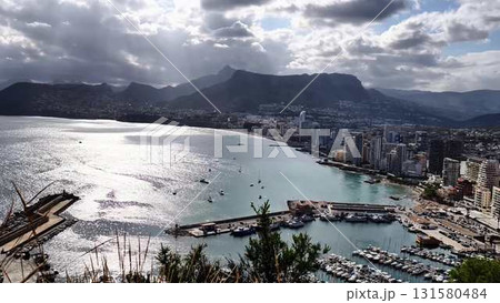 Stunning Aerial View of a Beautiful Coastal City Featuring a Marina and Majestic Mountains Stunning Aerial View of a Beautiful Coastal City Featuring a Marina and Majestic Mountains 131580484