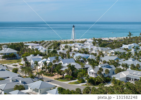 Boca Grande, Florida. Lighthouse on ocean shore for commercial vessels navigation. Expensive waterfront houses between green palm trees on Gasparilla Island Boca Grande, Florida. Lighthouse on ocean shore for commercial vessels navigation. Expensive waterfront houses between green palm trees on Gasparilla Island 131582248