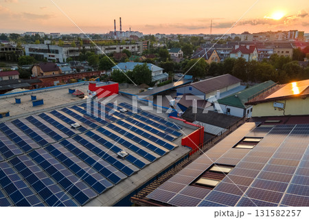 Blue photovoltaic solar panels mounted on building roof for producing clean ecological electricity at sunset. Production of renewable energy concept 131582257