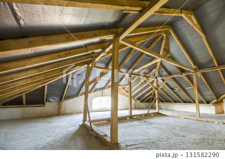 Attic of a building with wooden beams of a roof structure. Attic of a building with wooden beams of a roof structure. 131582290