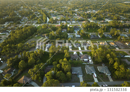 Aerial view of suburban landscape with private homes between green palm trees in Florida quiet residential area Aerial view of suburban landscape with private homes between green palm trees in Florida quiet residential area 131582338