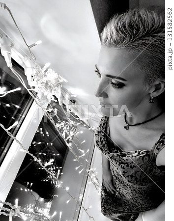 Woman Looking Down at Bright String Lights Woman Looking Down at Bright String Lights 131582562