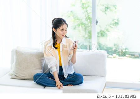 部屋でスマホを操作する女性 部屋でスマホを操作する女性 131582982