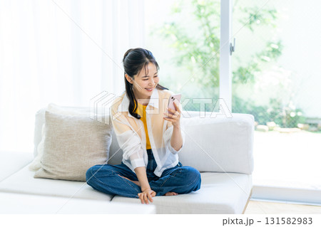 部屋でスマホを操作する女性 部屋でスマホを操作する女性 131582983