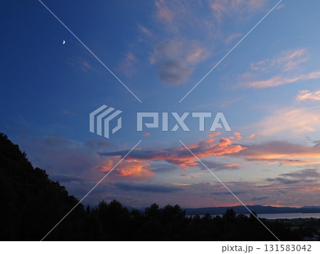 夕暮れ時、猪苗代湖上空に残照で赤く輝く雲と暗い青空に白く輝く月が印象的で綺麗だ。 夕暮れ時、猪苗代湖上空に残照で赤く輝く雲と暗い青空に白く輝く月が印象的で綺麗だ。 131583042