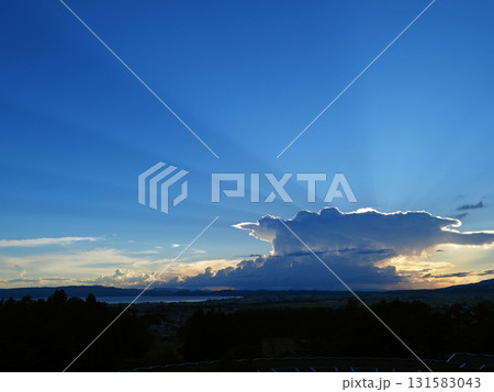 真夏の夕方、巨大な積乱雲が太陽を覆う。青空に向かって放射状に光が放され、ダイナミックで綺麗だ。 真夏の夕方、巨大な積乱雲が太陽を覆う。青空に向かって放射状に光が放され、ダイナミックで綺麗だ。 131583043