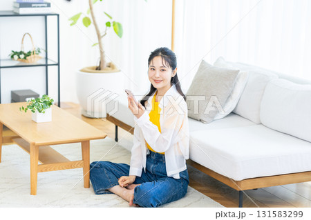 部屋でスマホを操作する女性 部屋でスマホを操作する女性 131583299