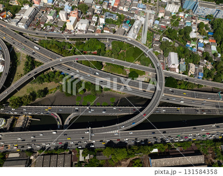 Aerial view of a complex highway network running through dense neighborhoods with some greenery. Bangkok, Thailand. Aerial view of a complex highway network running through dense neighborhoods with some greenery. Bangkok, Thailand. 131584358