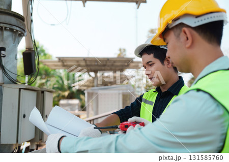 Sustainable Solutions and Renewable Energy Installation. Technicians working together on solar energy equipment at a renewable project site. 131585760