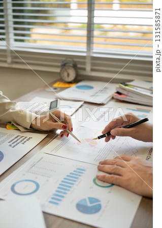 Business professionals analyzing data and discussing strategies with charts and reports. Business professionals analyzing data and discussing strategies with charts and reports. 131585871