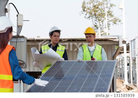 Collaborative planning for solar technology. Engineers surveying solar panels and discussing installation processes. 131585939