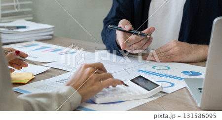 Business professionals discussing financial strategies with documents and calculator 131586095