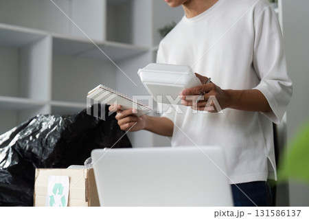 Individual organizing recyclable materials and notepads for donation and recycling. Individual organizing recyclable materials and notepads for donation and recycling. 131586137