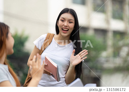 Cheerful university student greeting a friend outdoors, promoting education and friendship Cheerful university student greeting a friend outdoors, promoting education and friendship 131586172