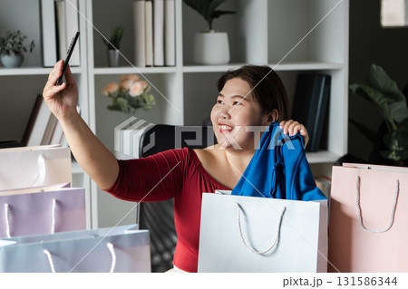 Joyful woman celebrating her online shopping haul with credit card and smartphone in a modern office. Joyful woman celebrating her online shopping haul with credit card and smartphone in a modern office. 131586344