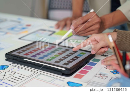Collaborative Design. Team brainstorming on digital interface mockups and color palettes. Collaborative Design. Team brainstorming on digital interface mockups and color palettes. 131586426