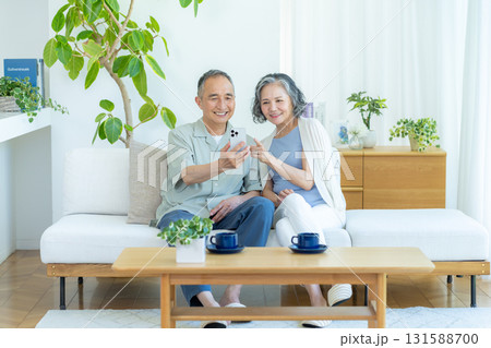 リビングでスマホを見るシニア夫婦 リビングでスマホを見るシニア夫婦 131588700