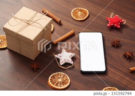 smarthone with white screen and christmas decorations on walnut table 131592794