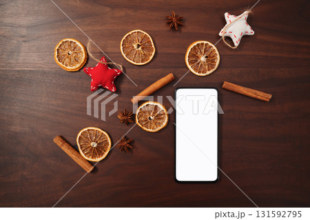 flat lay with smarthone and christmas decorations on walnut table 131592795