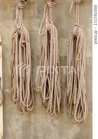 海辺の倉庫の壁に、様々な種類のロープの束がぶら下がっている。 131592888