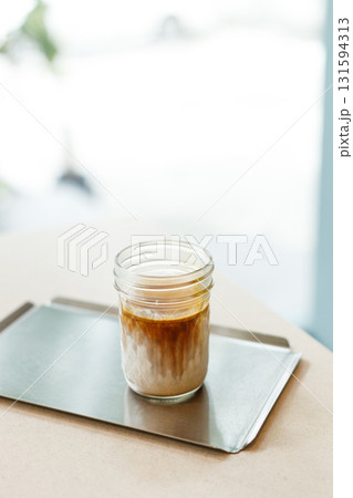 Cup of chilled milk dirty coffee on table by the window. Selective focus. 131594313