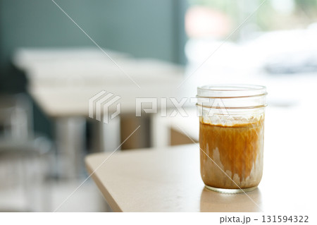 Cup of chilled milk dirty coffee on table by the window. Selective focus. Cup of chilled milk dirty coffee on table by the window. Selective focus. 131594322