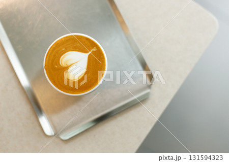 Cup of hot milk latte coffee with heart shape latte art on table. 131594323